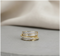 Stack of gold and diamond rings on a textured surface
